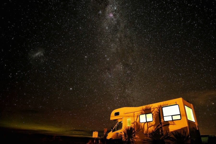 Obytný voz pod nočnou oblohou s hviezdami