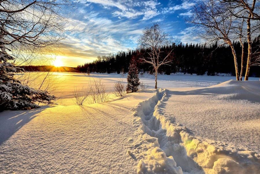 Vyšliapaná cesta v hlbokom snehu pri západe slnka