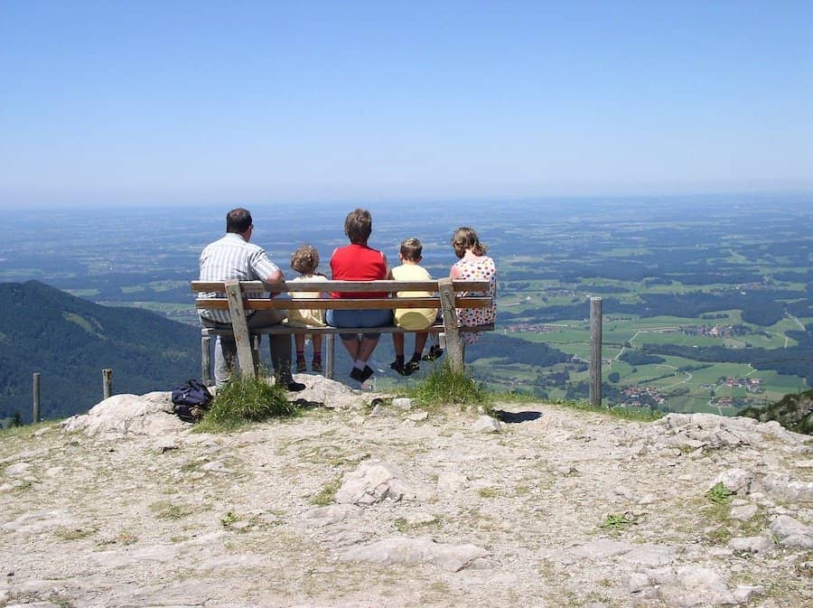 Rodina sediaca na lavičke na vrchole kopca