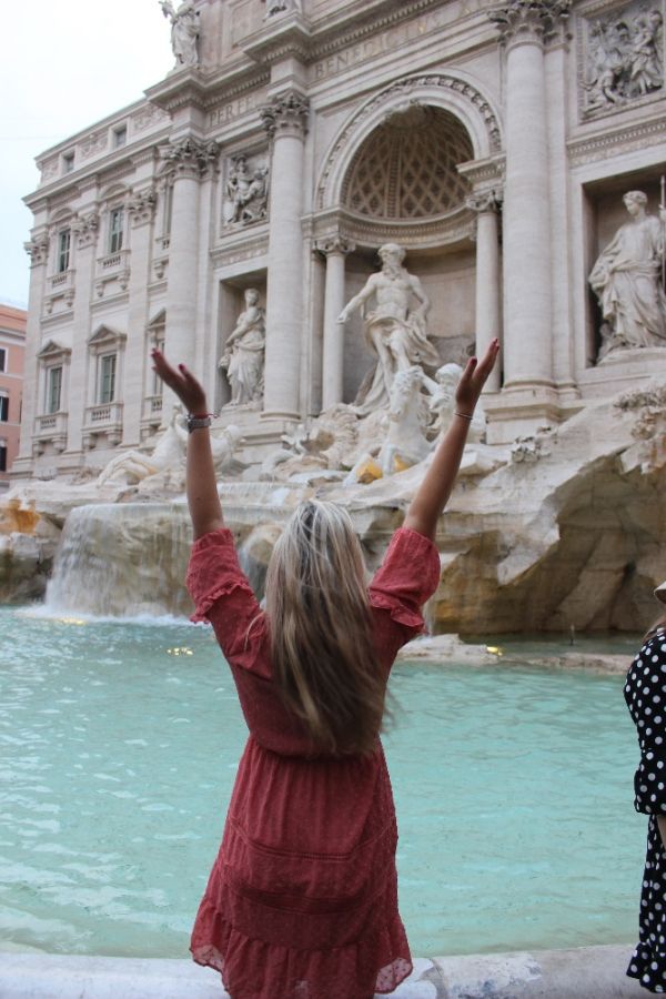 Dievča pred fontánou vody v historickej časti mesta v Taliansku