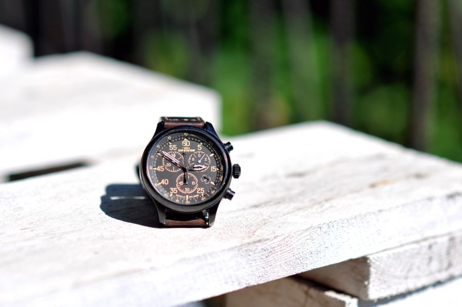 Luxusné analógové hodinky na palete na slniečku