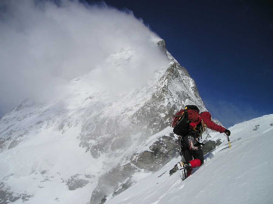 Muž s batohom a kvalitnou výbavou lezúci na Matterhorn