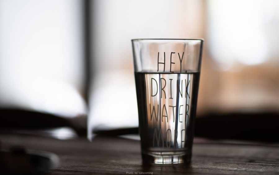 Pitná voda v pohári s nápisom Pij viac vody